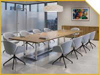 Modern conference room with a long wooden table and light gray rolling chairs, large windows with a city view, pendant lights, and a colorful abstract painting on the wall.